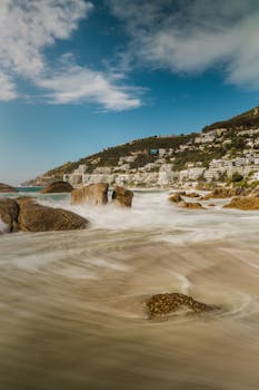 A Yellow Car Parked on a Street Covered with Autumn Leaves under Vibrant Fall Foliage