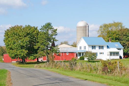 Picturesque countryside house surrounded by trees and a vibrant blue sky