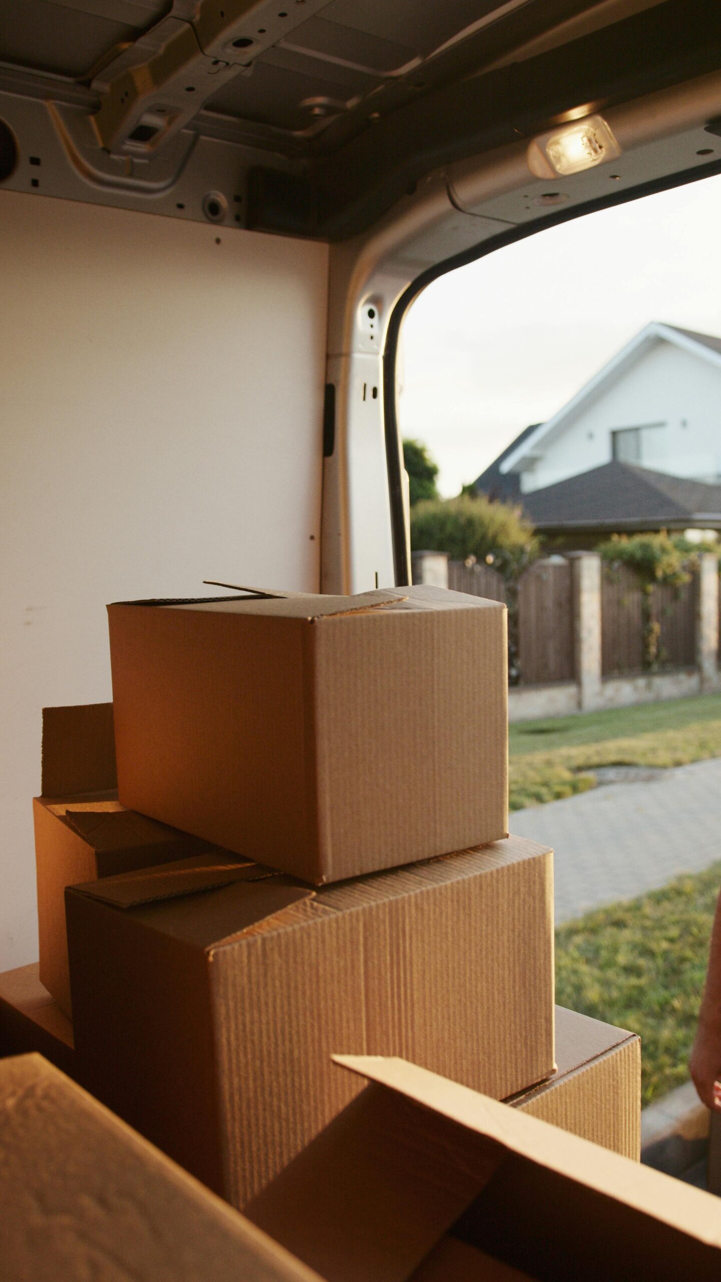 A person overwhelmed by cardboard boxes during a home move, symbolizing stress and relocation.