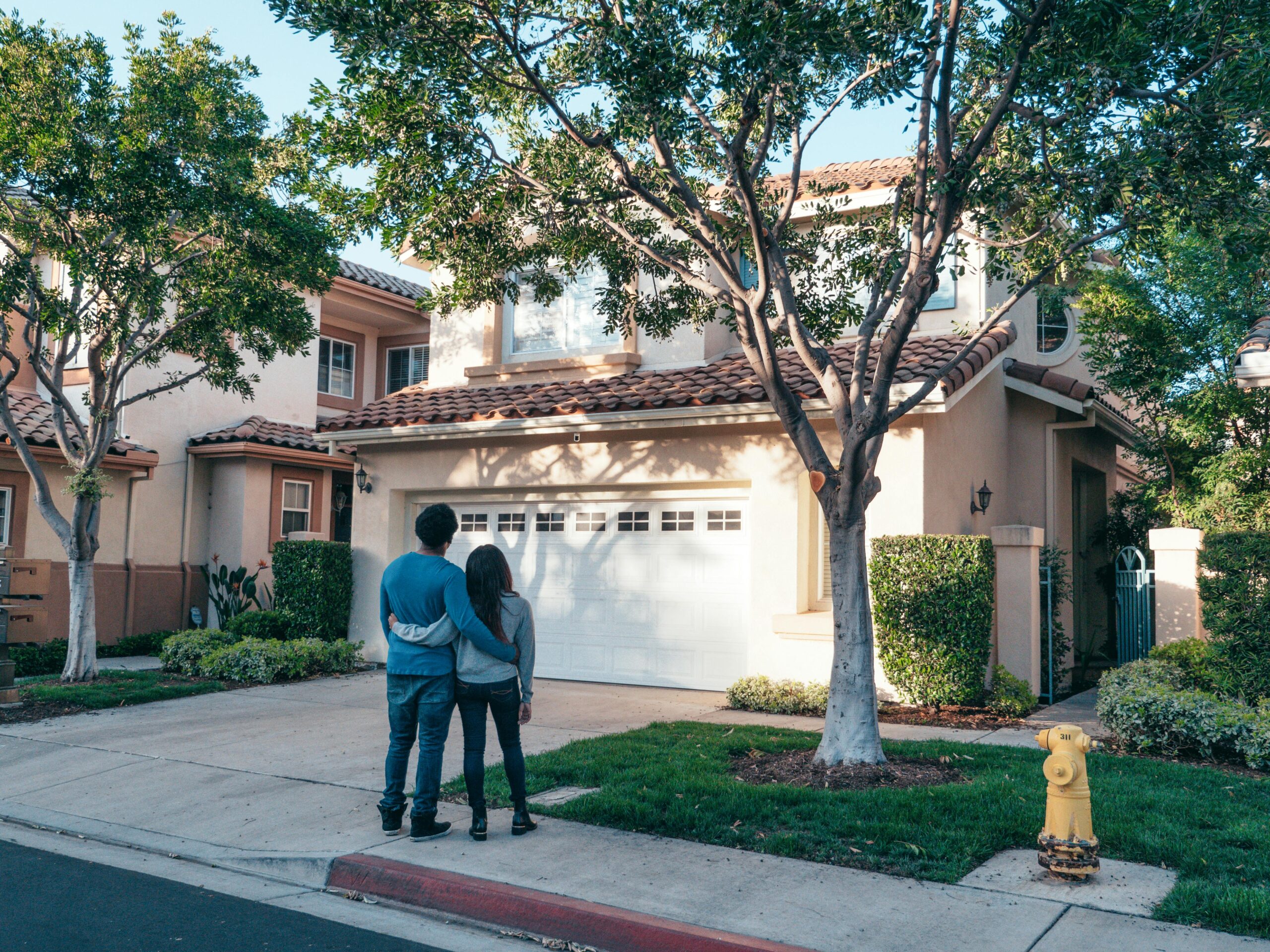 Canadian family standing in front of their rented house under a rent-to-own agreement.