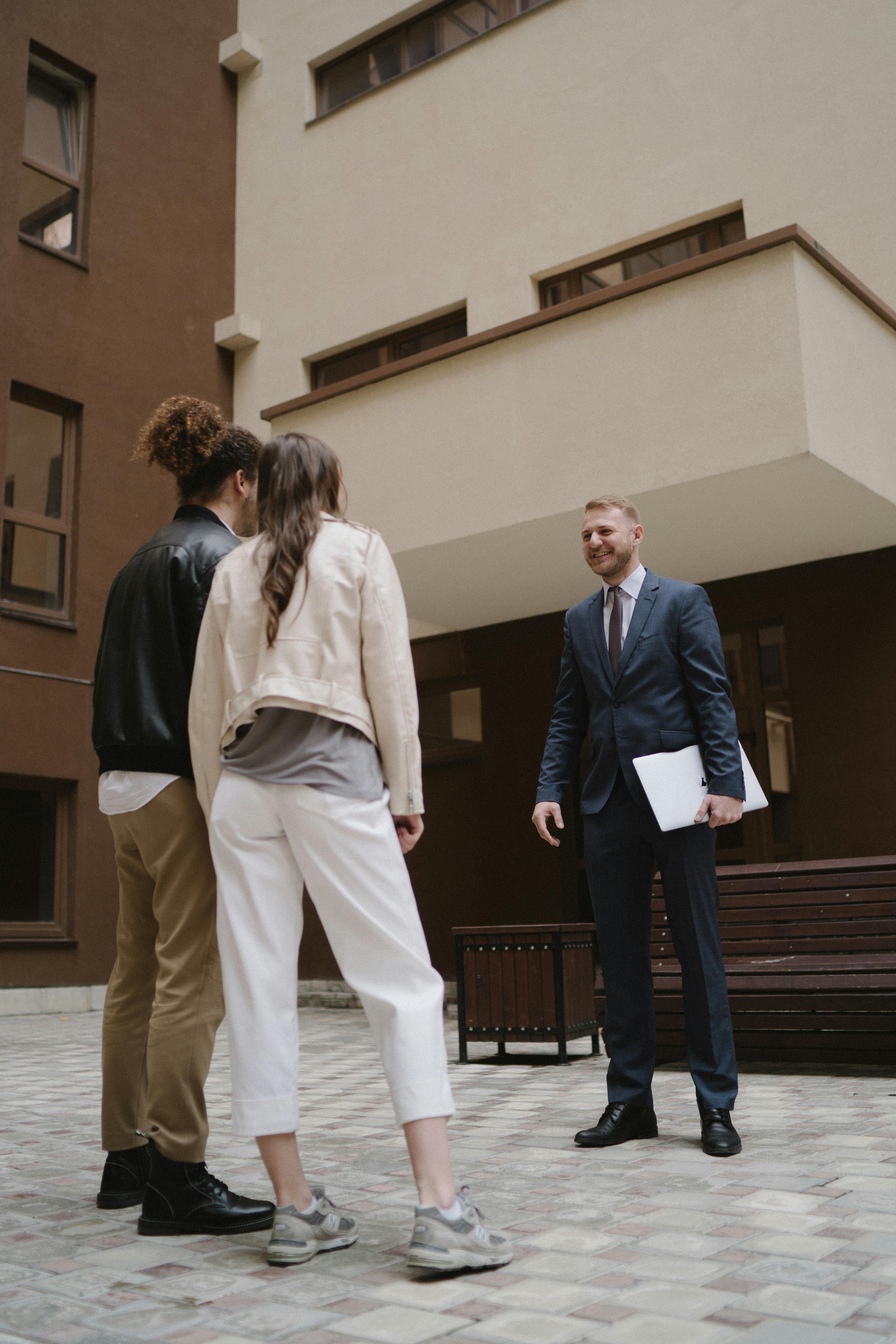 A real estate agent shows an apartment to a couple, illustrating a property tour experience