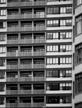 A striking black and white photo of a modern building facade featuring geometric patterns, lines, and symmetry. Canadian Rent Own Living Options for 2024