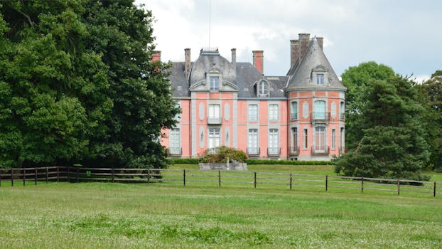 Beautiful historic château in Bacilly, Normandy, France, surrounded by lush greenery.