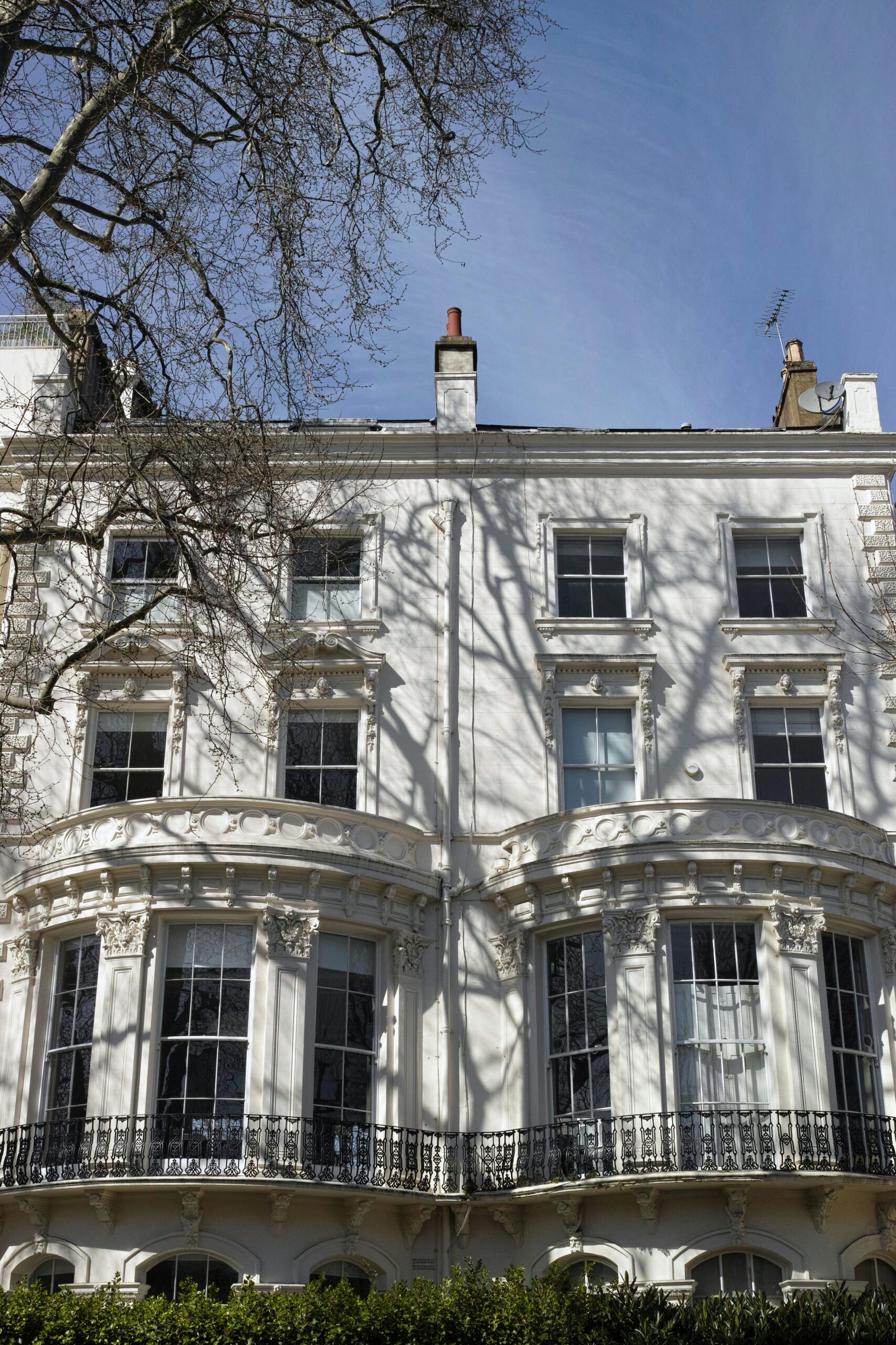 Motorcyclist on motorbike parked in front of a classic suburban house.